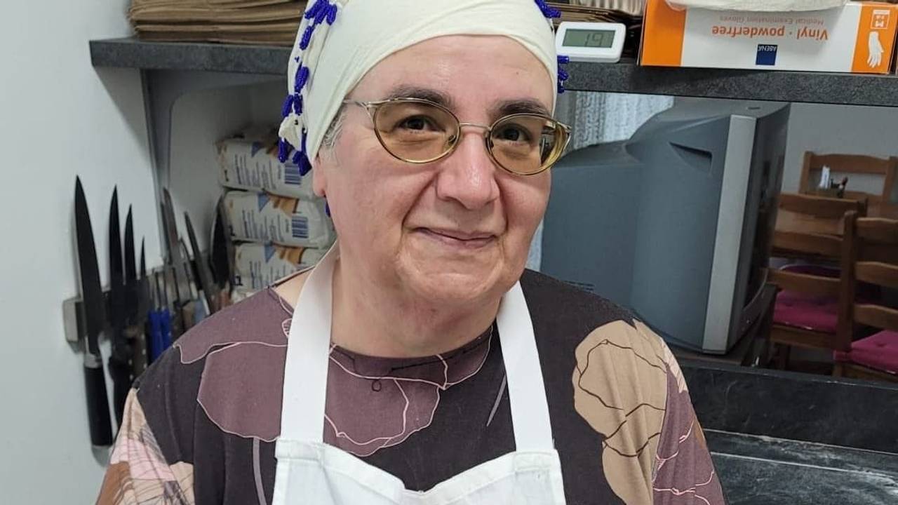 Eine Frau steht in einer Küche und hält einen Teller mit Essen in den Händen.