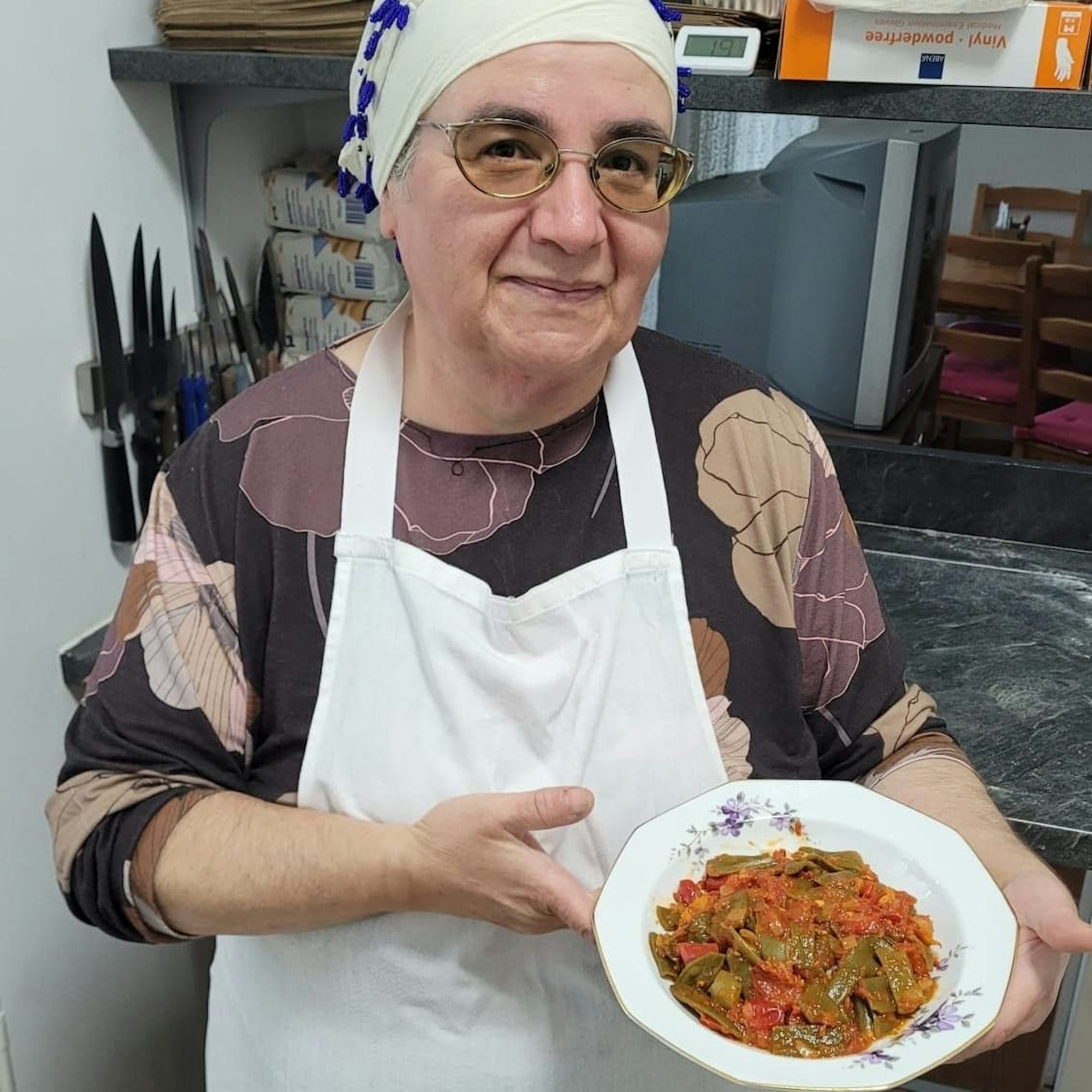 Eine Frau steht in einer Küche und hält einen Teller mit Essen in den Händen.