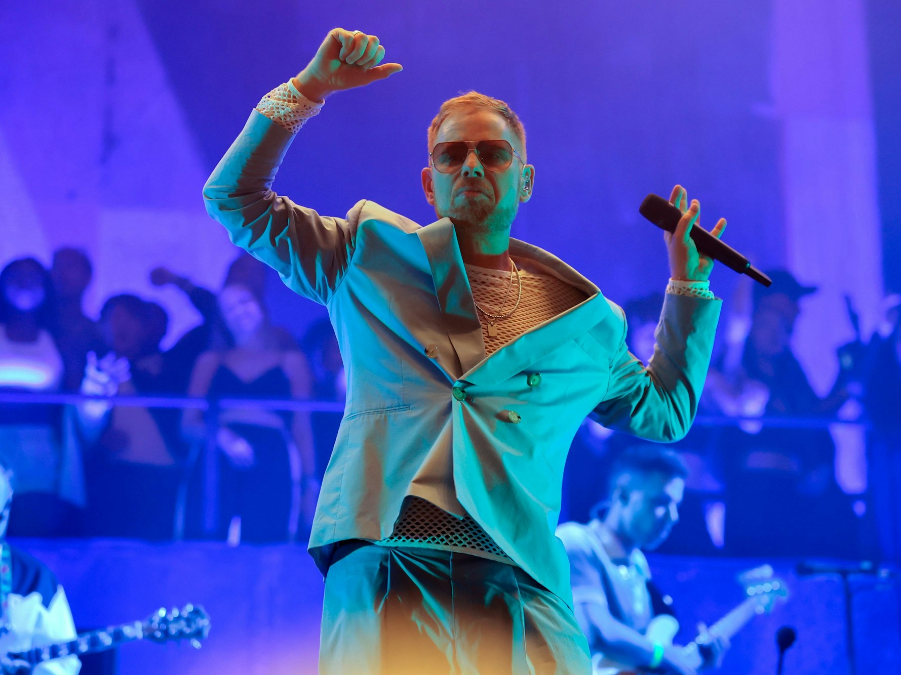 Peter Fox steht im Anzug auf der Bühne und tanzt zu einem Lied.