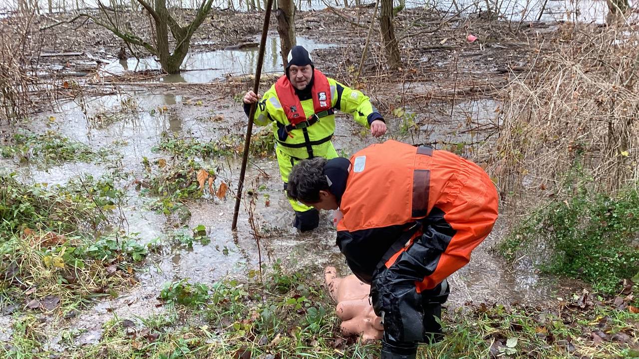 Ein Feuerwehrmann zieht eine nackte weibliche Puppe an Land.