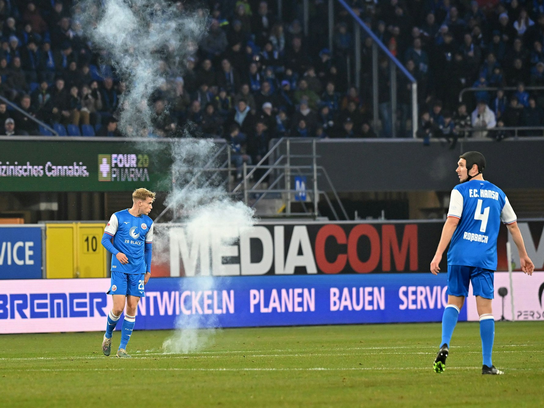 Ein Feuerwerkskörper landet am Freitag (15. Dezember 2023) knapp neben Rostocks Felix Ruschke (l.).