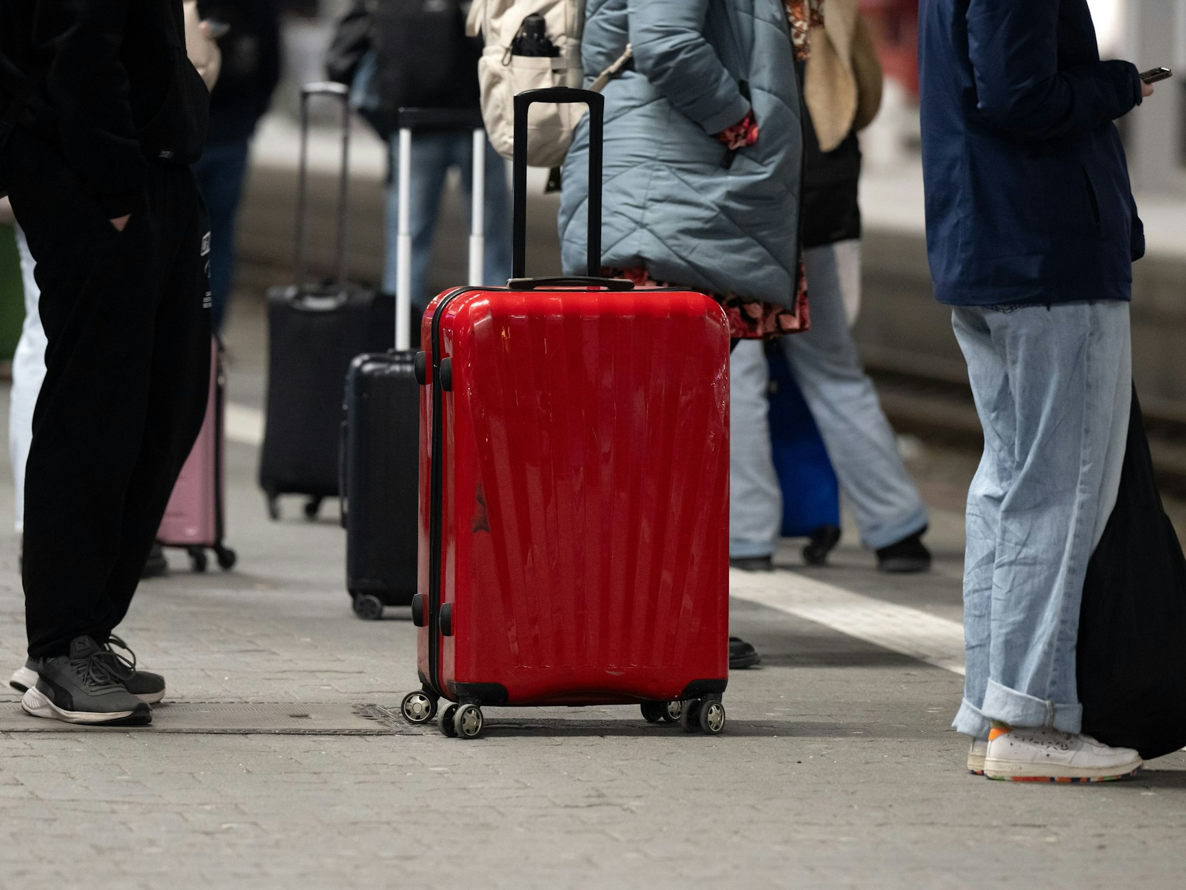 Bahnreisende warten auf einem Bahnsteig am Hauptbahnhof.