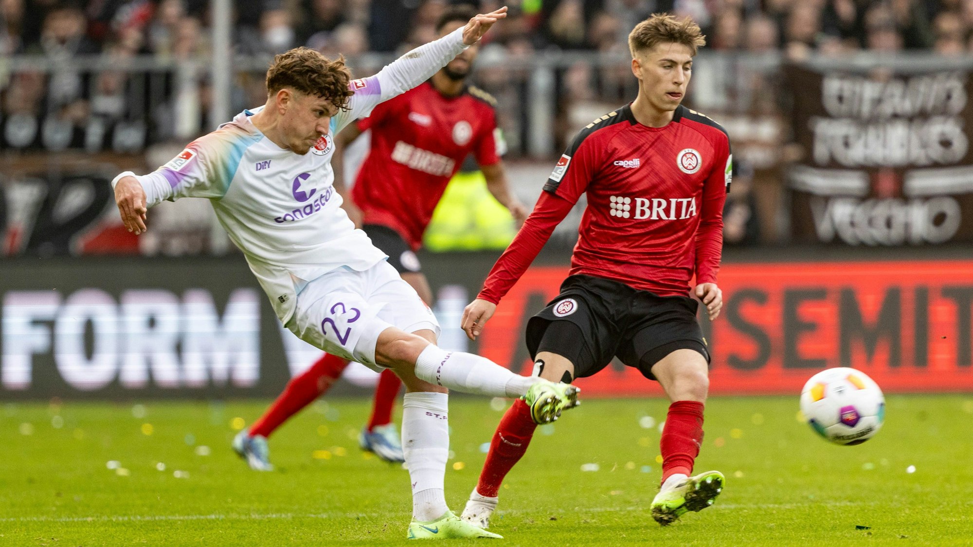 St. Paulis Philipp Treu (l) schießt, neben ihm steht Wiesbadens Robin Heußer