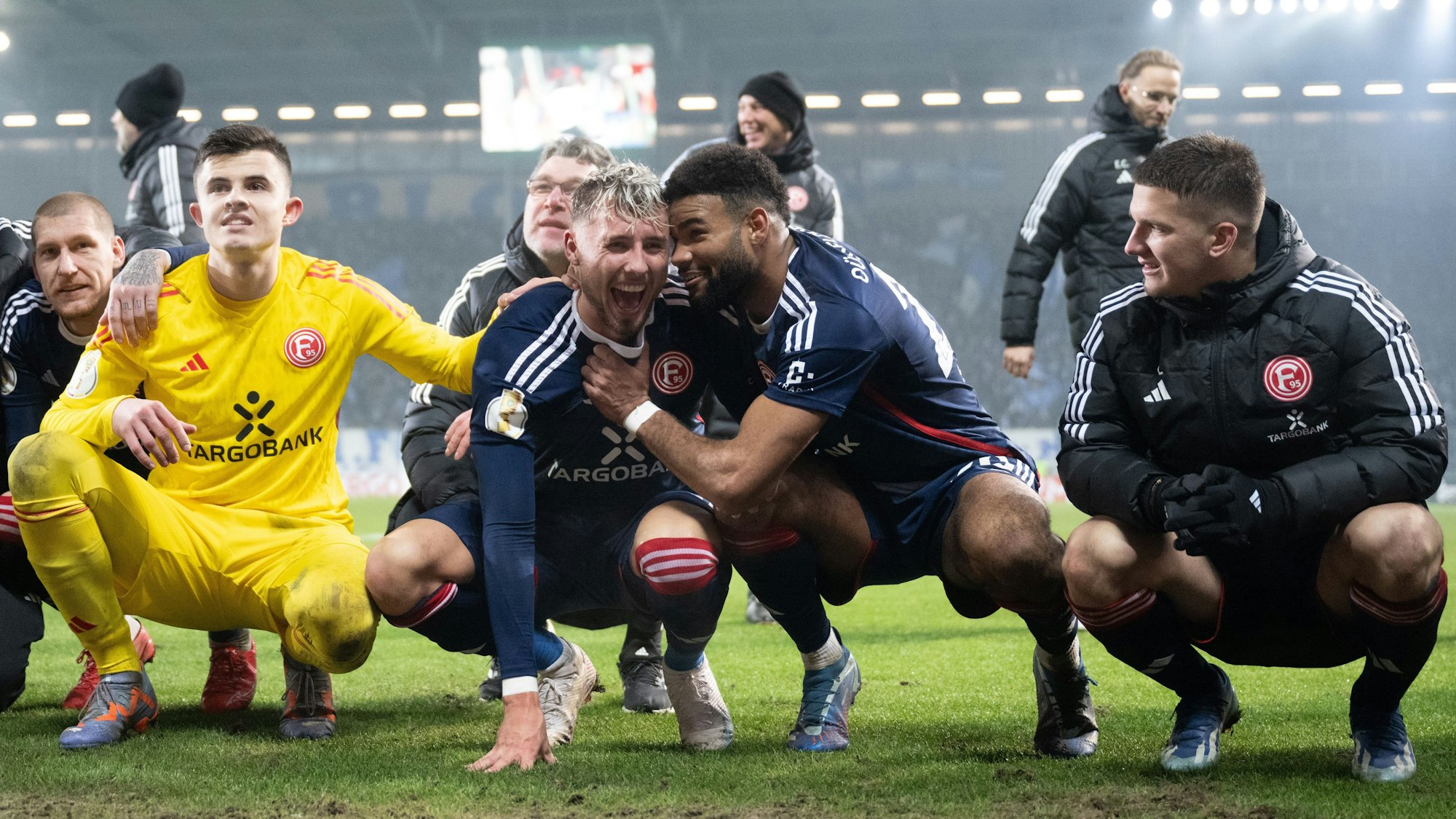 Düsseldorfs Mannschaft mit Torschütze Jona Niemiec (M) freut sich über den Sieg in Magdeburg.