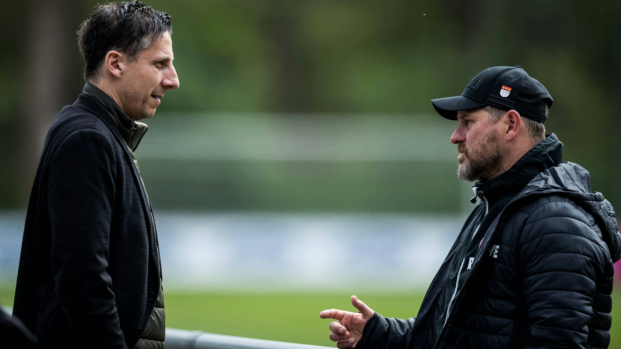 Steffen Baumgart und Christian Keller sprechen am Rande eines Trainings am Geißbockheim.
