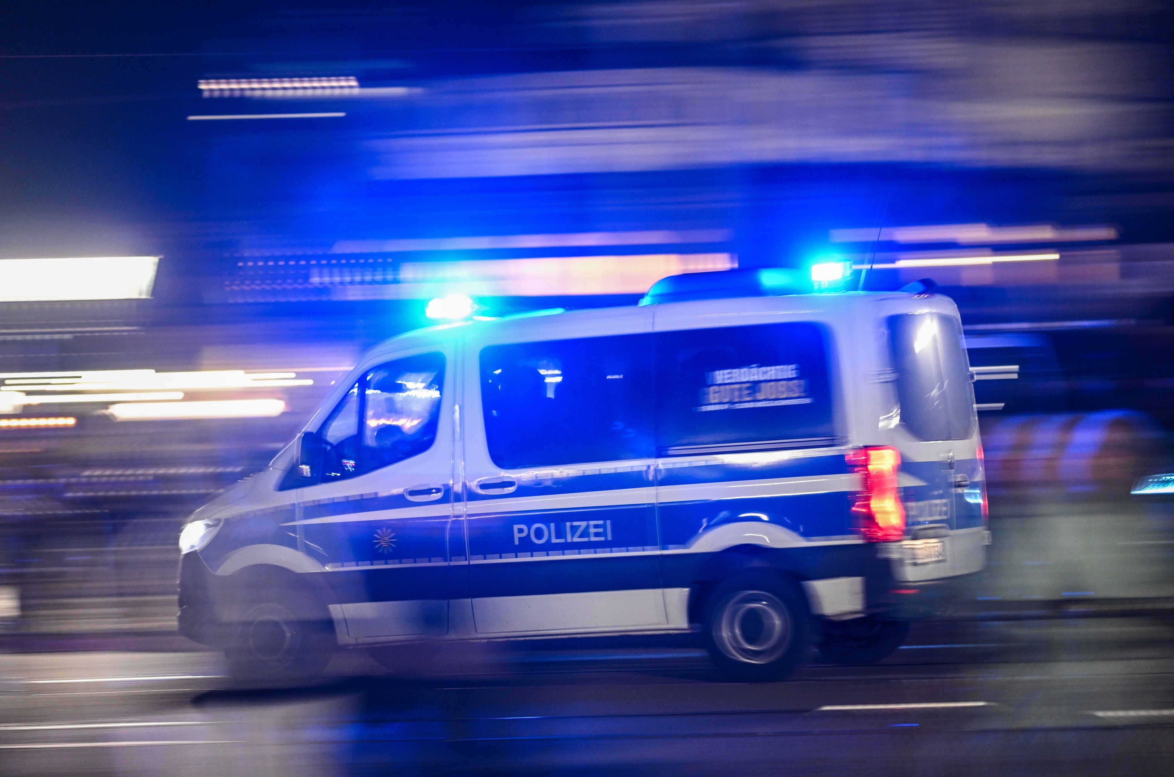 Ein Polizeiauto fährt mit Blaulicht eine Straße entlang (Symbolfoto).