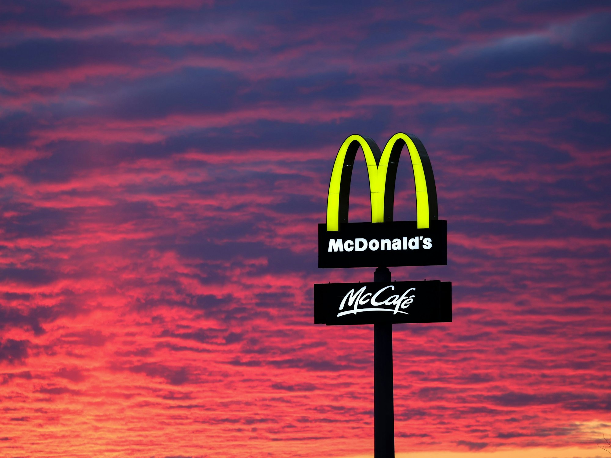 Der Abendhimmel leuchtet hinter einem McDonald's-Logo (Symbolbild): Nach einem Erbfolgestreit hat sich Carla von Hessen mit der Fastfood-Kette geeinigt.