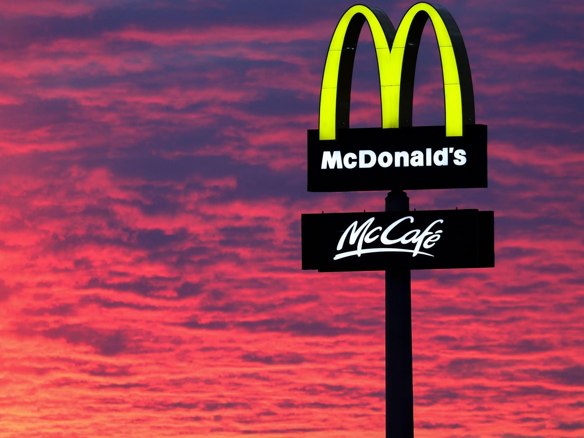 Der Abendhimmel leuchtet hinter einem McDonald's-Logo. McDonald's gibt am 25.04.2023 Zahlen für das 1. Quartal bekannt. +++ dpa-Bildfunk +++