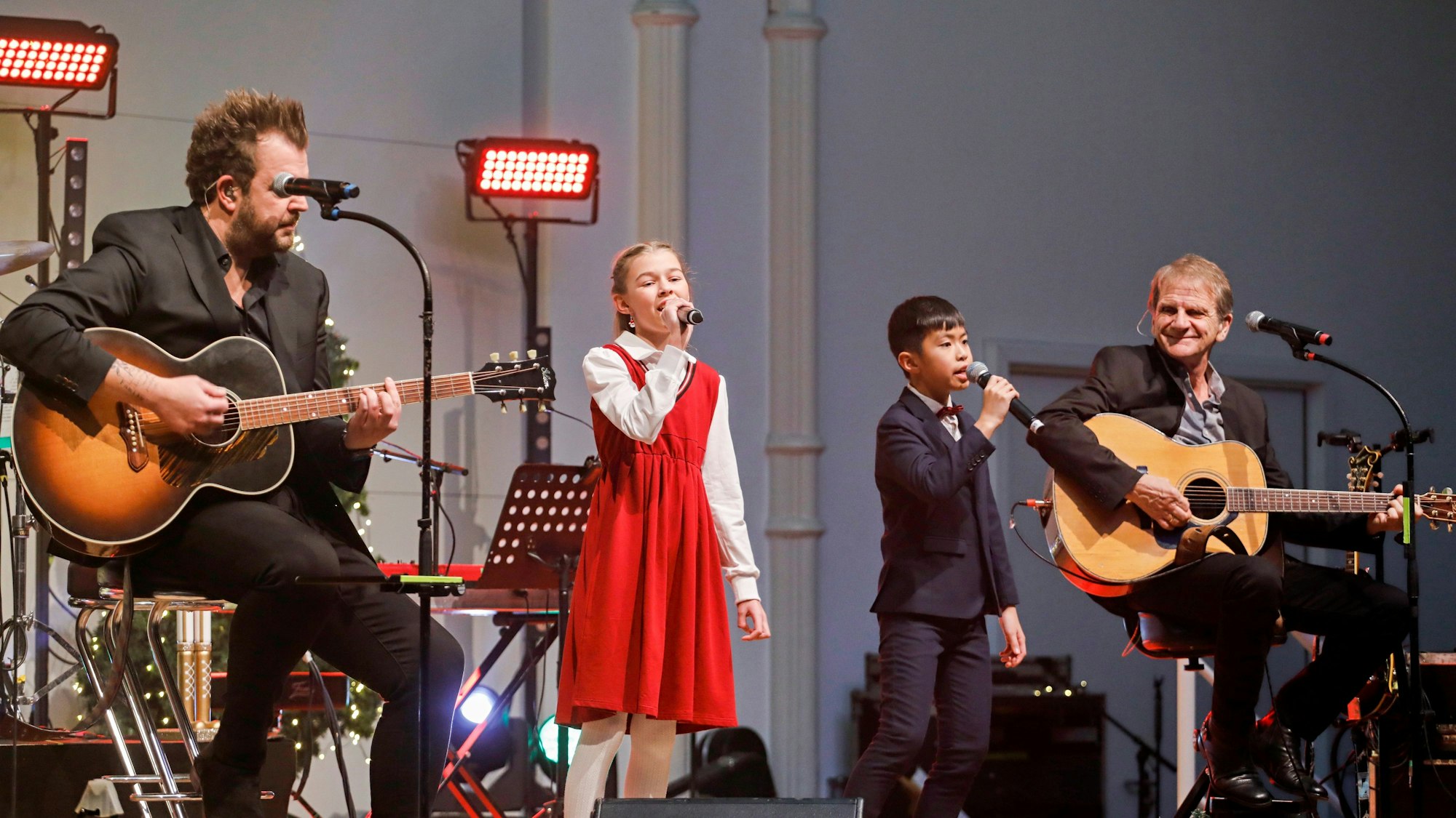 Zwei Kinder singen mit den Paveiern auf der Bühne.