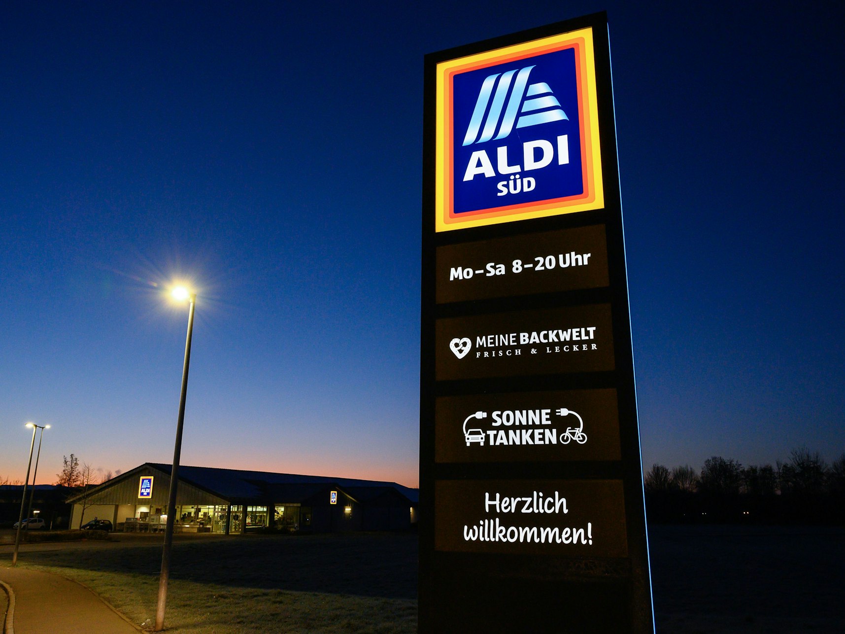 Ein Schild des Discounters Aldi Süd leuchtet vor einer Filiale: Der Discounter nimmt ein Hype-Getränk in sein Sortiment auf.