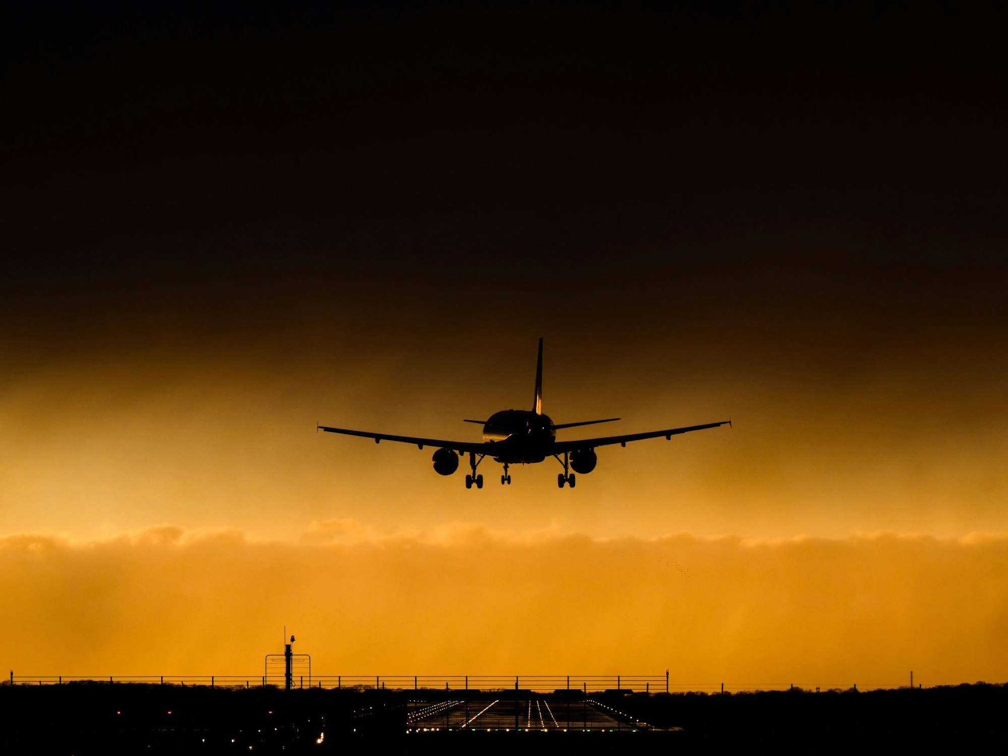 Ein Flugzeug landet vor einer bedrohlichen Wolkenkulisse am Flughafen Hannover, hier im Februar 2022.