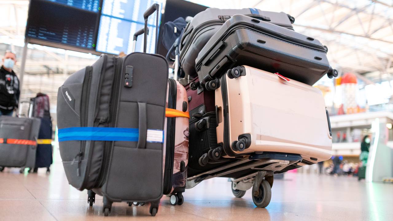 Mehrere Koffer liegen auf einem Gepäckwagen in einer Schlange vor einem Check-in-Schalter, hier im Oktober 2021 in Hamburg.
