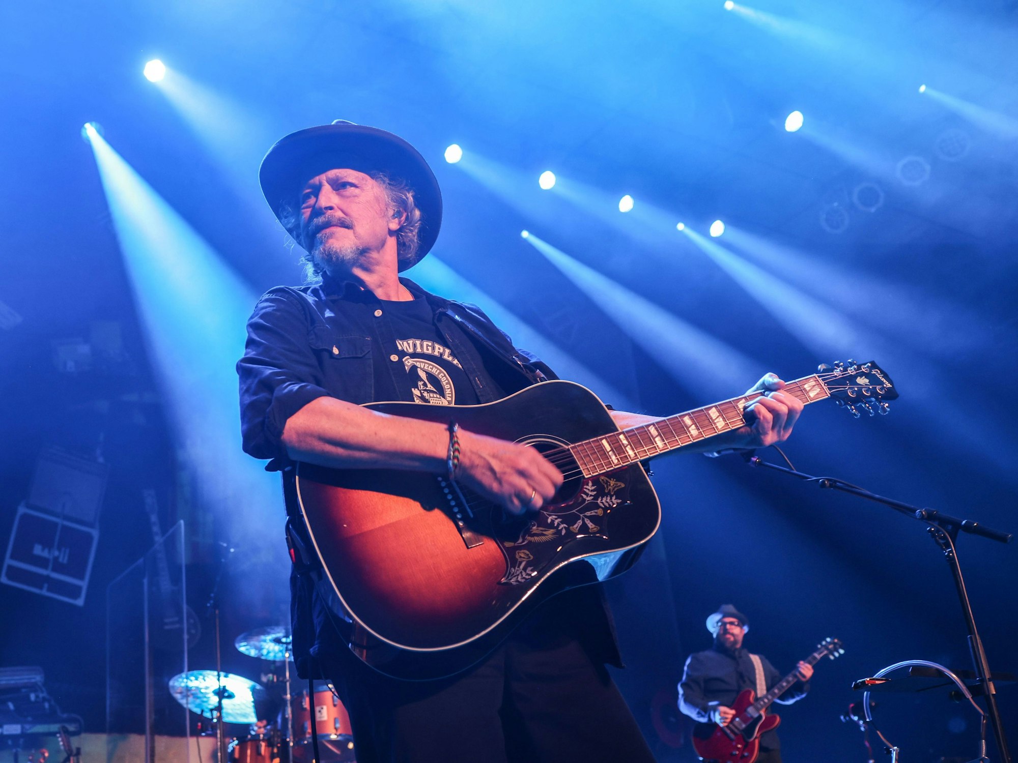 Wolfgang Niedecken mit Gitarre auf einer dunklen Bühne in Köln.