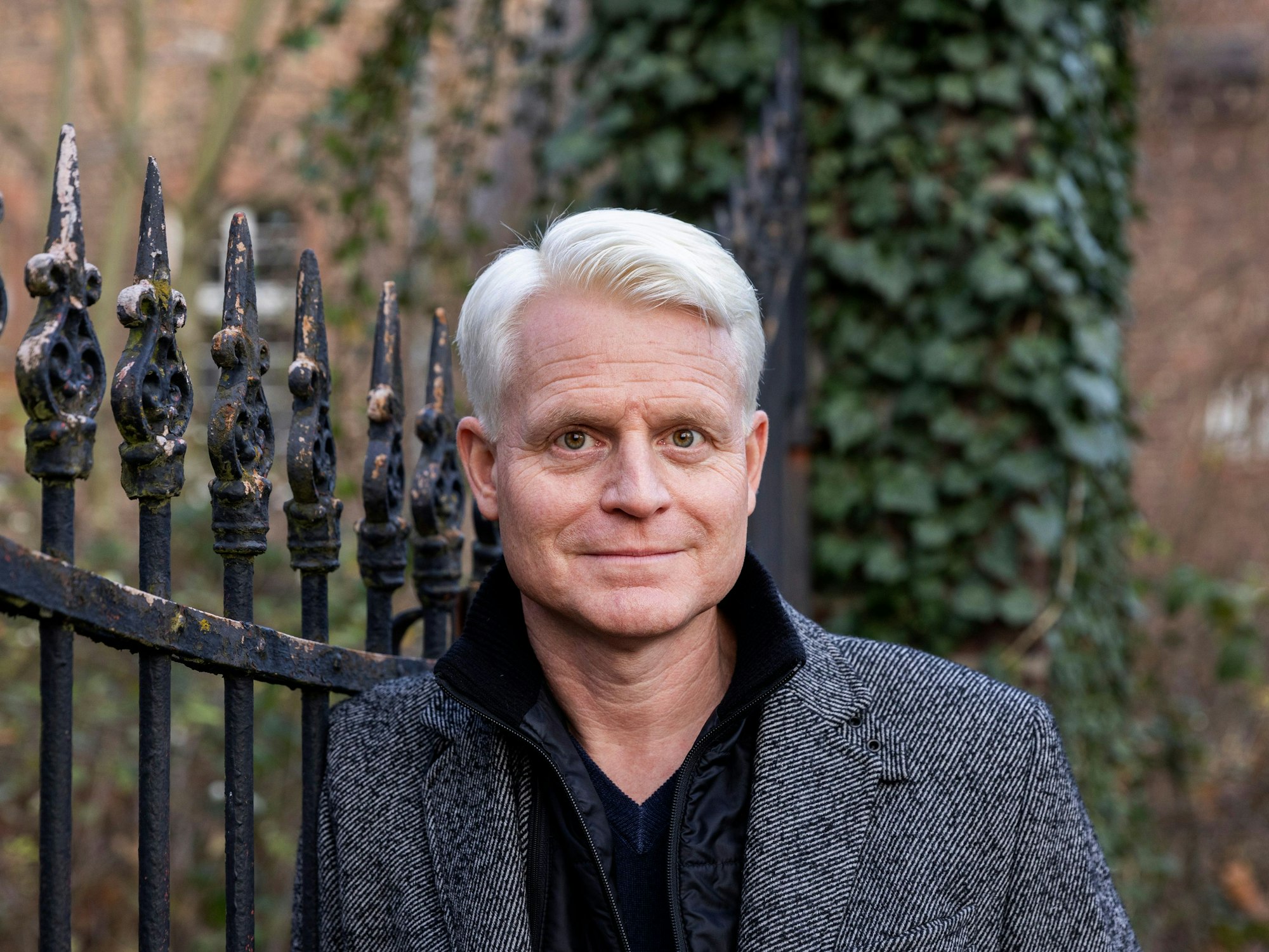 Guido Cantz lehnt an einem Zaun und schaut in die Kamera.