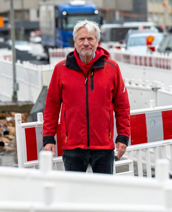 Jürgen Becker steht zwischen Baustellenbaken auf einer Baustelle in Köln.