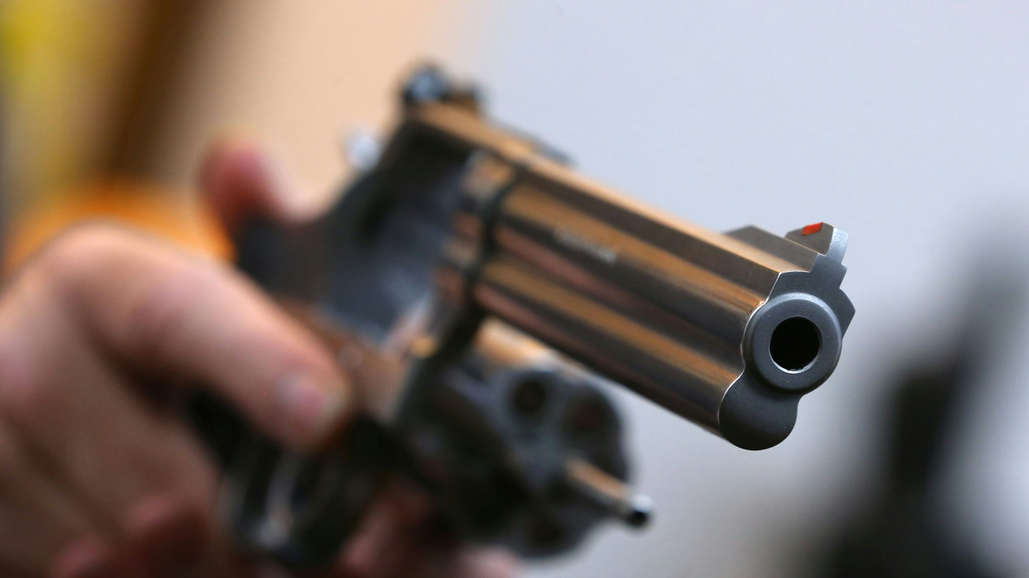 Ein Mann hält in einem Waffengeschäft einen Revolver des Herstellers Smith & Wesson.