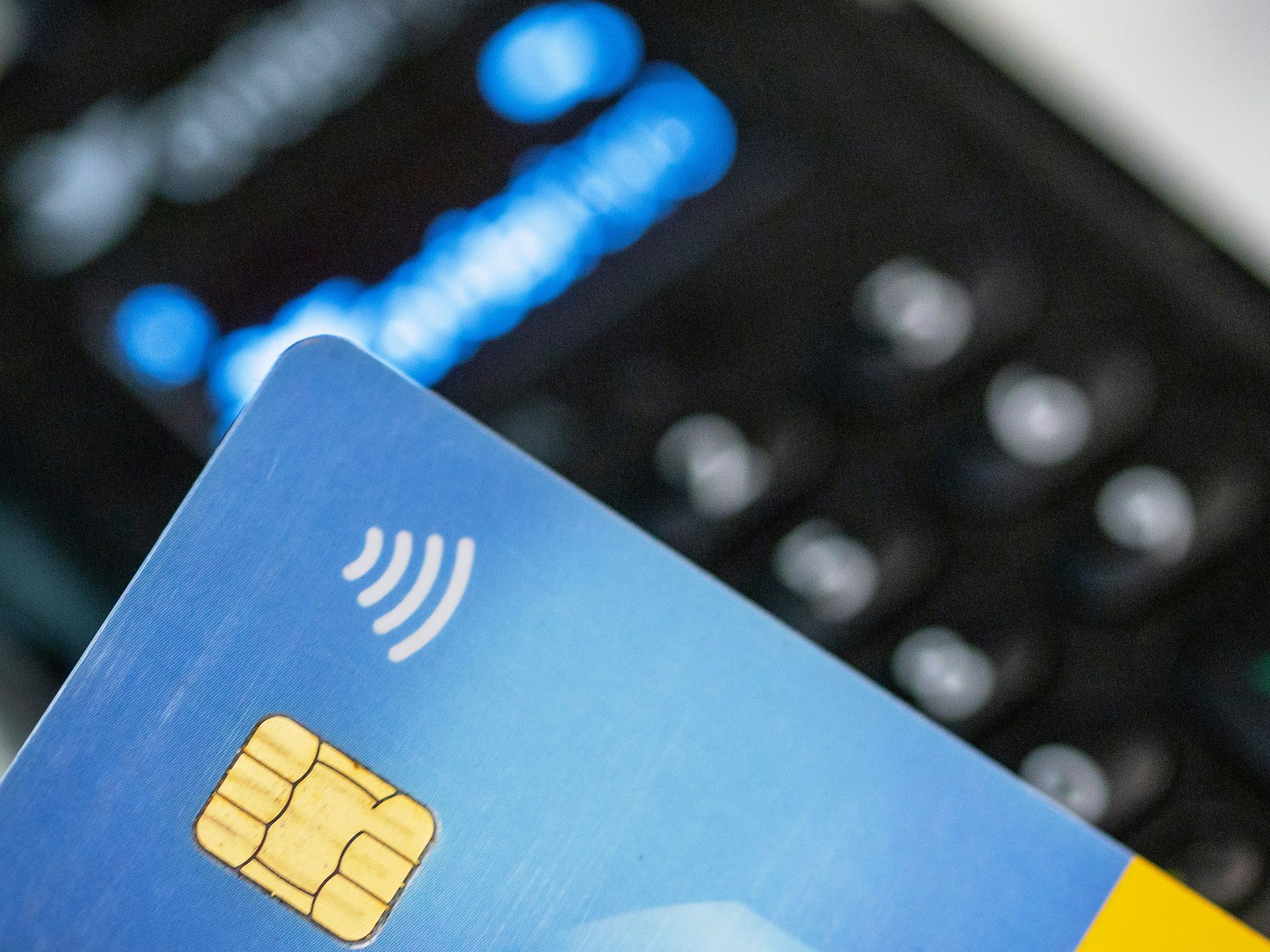 Eine Person hält ihre Girokarte über ein EC-Lesegerät zwecks kontaktlosem Bezahlen, hier im Juni 2023 in Berlin.