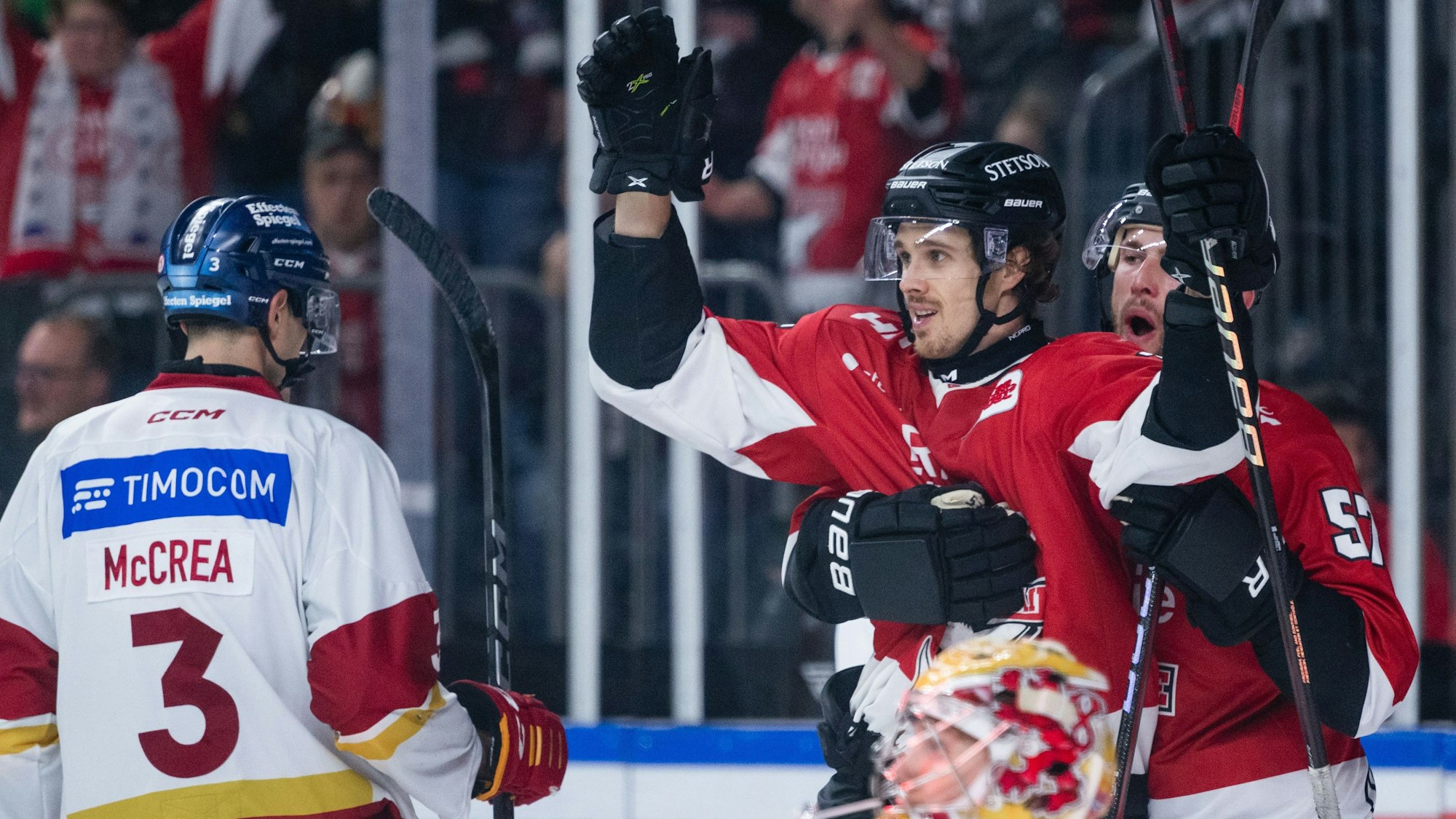 Kölns Torschütze Louis-Marc Aubry (M.) und Brady Austin (r.) jubeln nach dem Treffer zum 2:1.