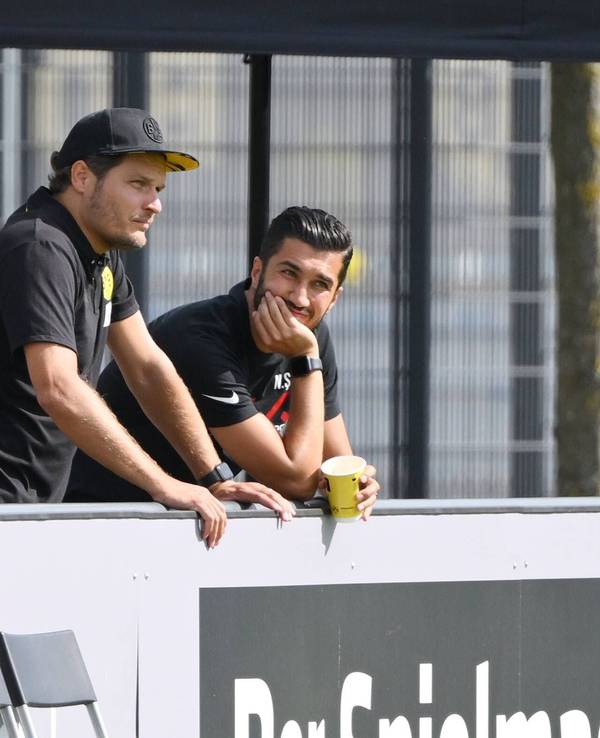 BVB-Trainer Edin Terzic und Antalyaspor-Coach Nuri Sahin unterhalten sich am Spielfeldrand.