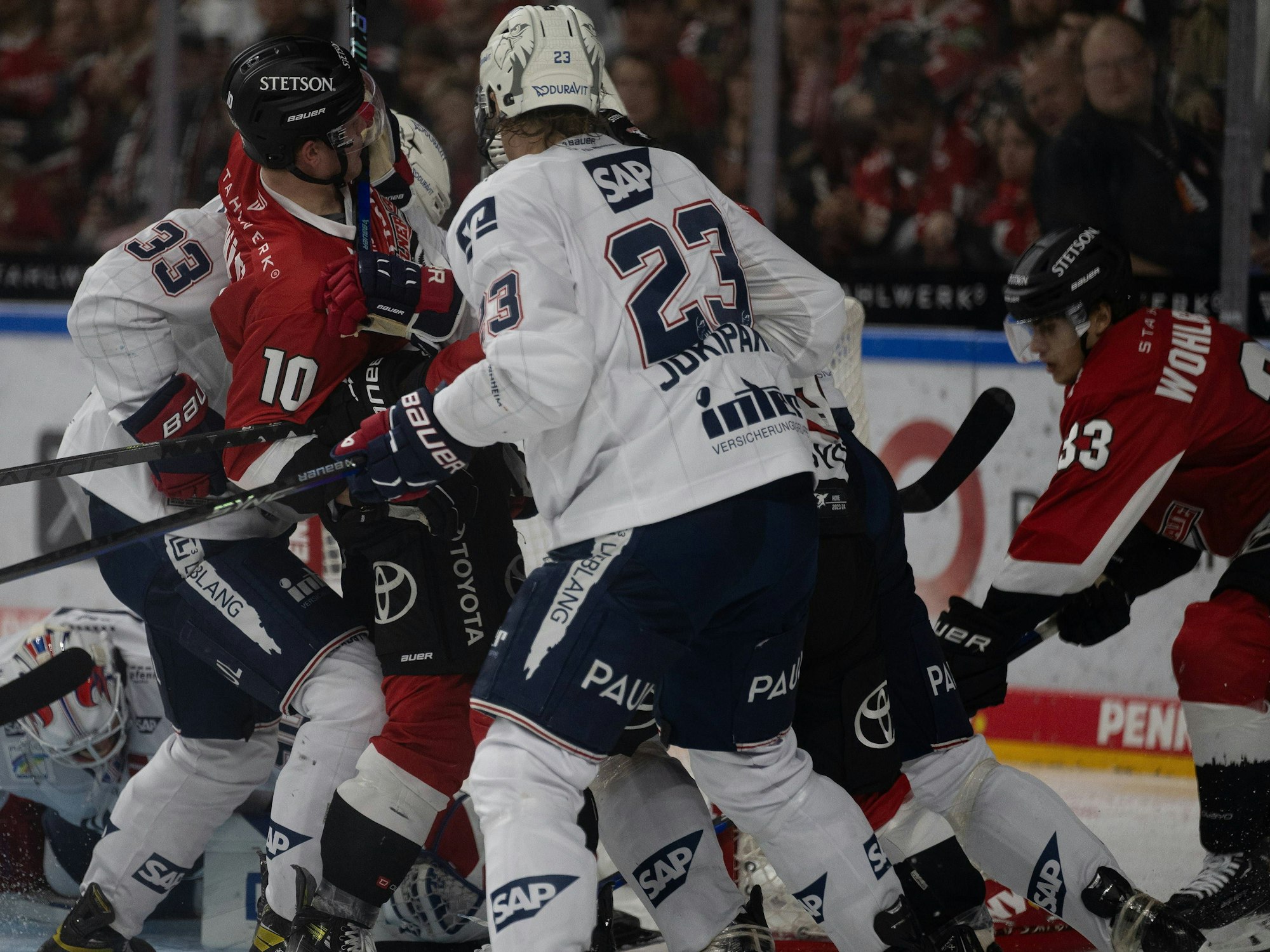 Kölner und Mannheimer Spieler kämpfen vor dem Tor um den Puck.