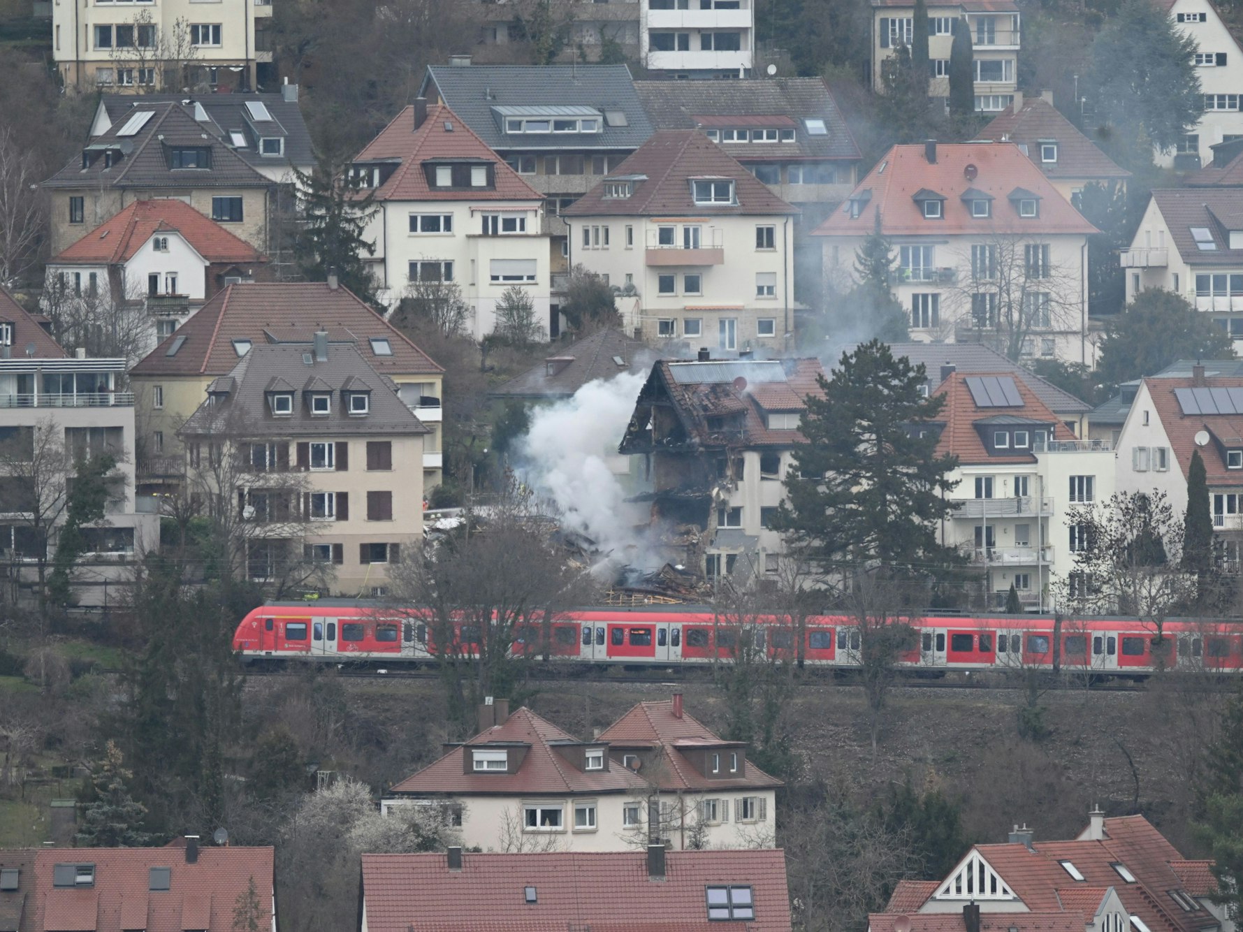 An der Unglücksstelle in Stuttgart West löschen Feuerwehrleute den Brand und suchen nach einer vermissten 85-jährigen Bewohnerin. Nach einer Explosion in der Nacht in einem Wohnhaus in Stuttgart sind Teile des Gebäudes eingestürzt.