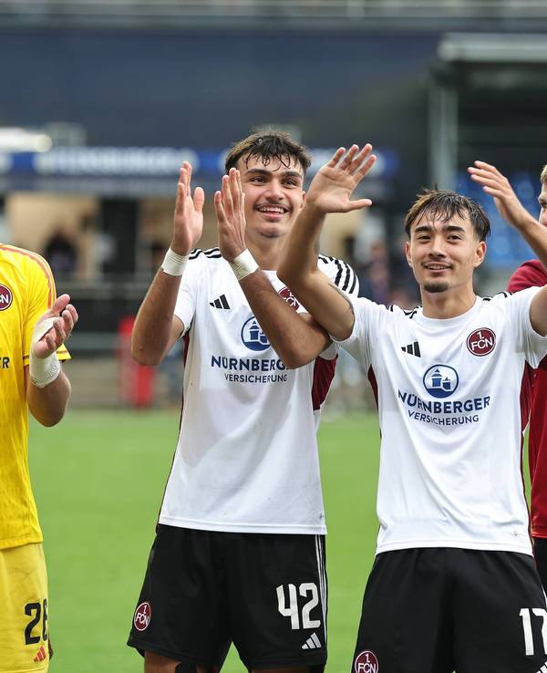 Die Nürnberg-Profis Christian Mathenia, Can Uzun, Jens Castrop und Finn Jeltsch feiern gemeinsam vor dem Fanblock.