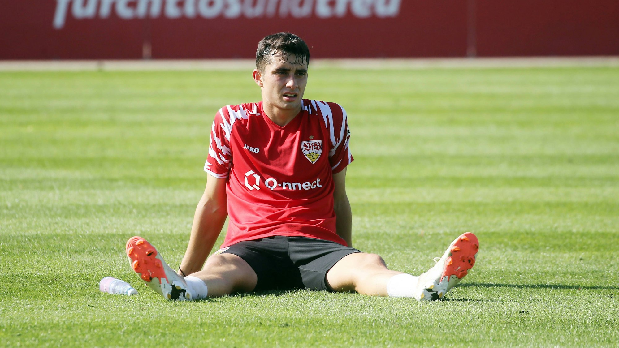 Thomas Kastanaras sitzt bei einer Trainingseinheit des VfB Stuttgart auf dem Rasen.