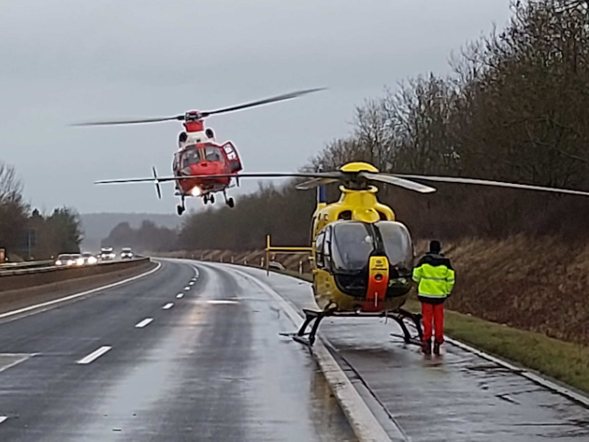 Ein Rettungshubschrauber steht auf der gesperrten Autobahn, ein zweiter ist im Landeanflug.