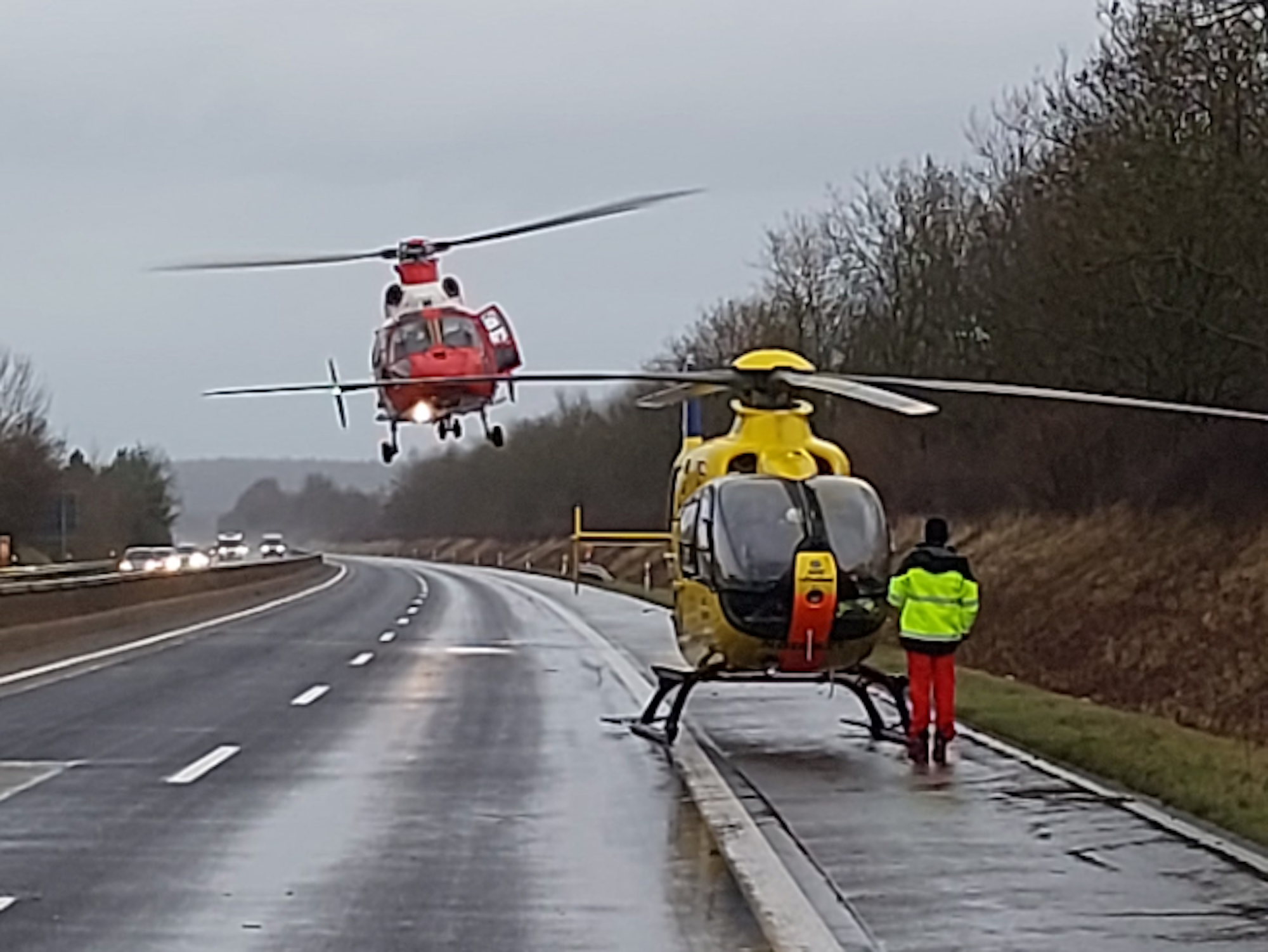 Ein Rettungshubschrauber steht auf der gesperrten Autobahn, ein zweiter ist im Landeanflug.