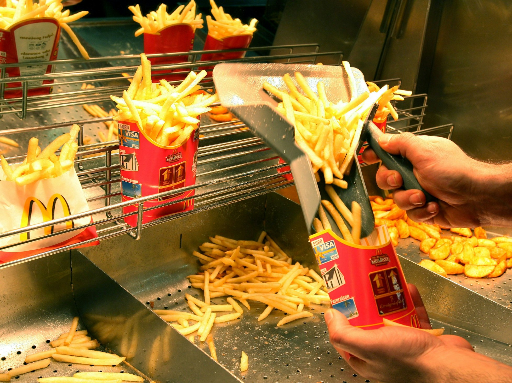 Ein Mitarbeiter der Filiale von McDonald's in Ludwigsburg füllt in der Fast-Food-Kette Pommes Frites ab, hier im Dezember 2007.