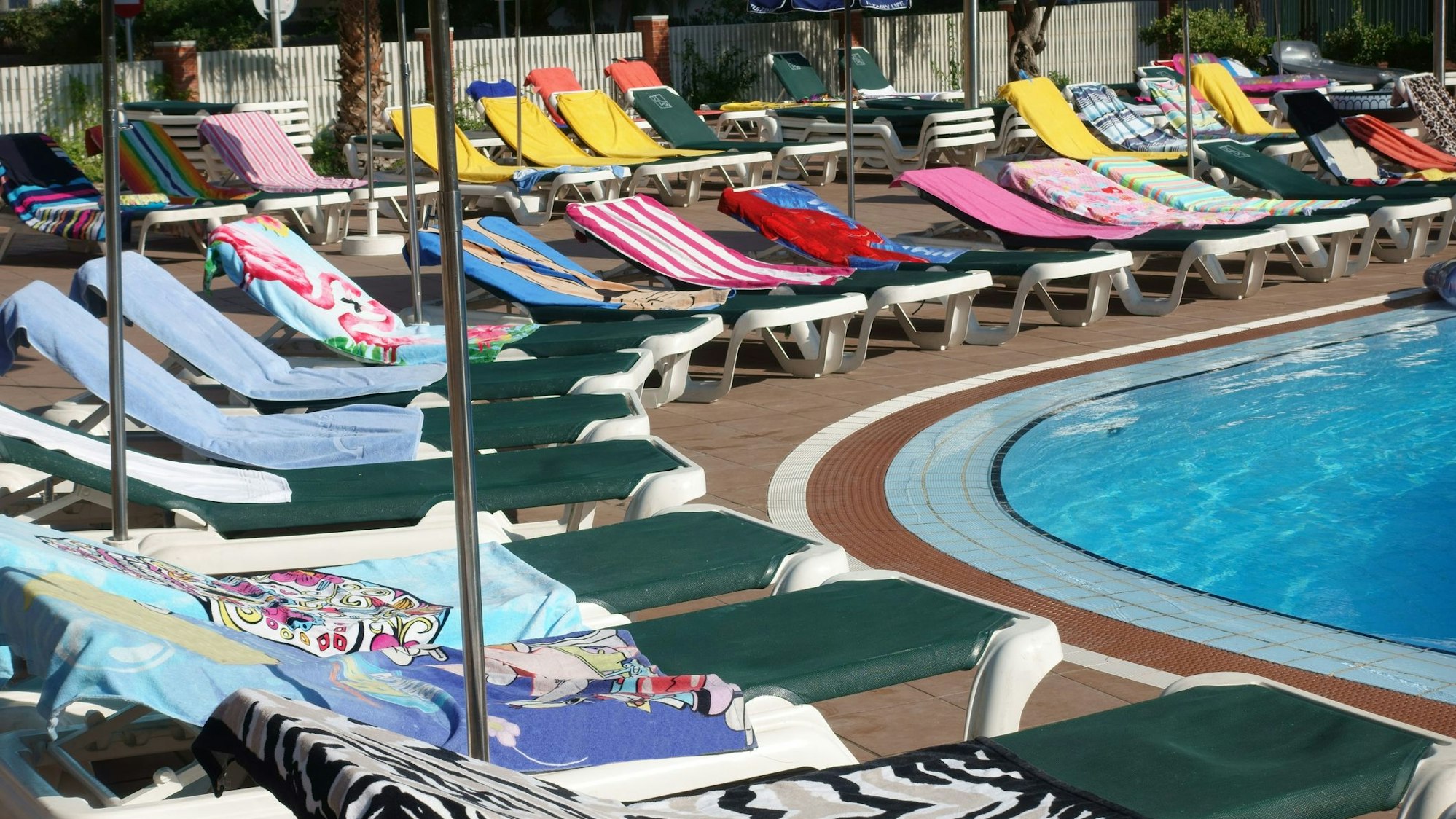 Leere Poolliegen mit Handtüchern
