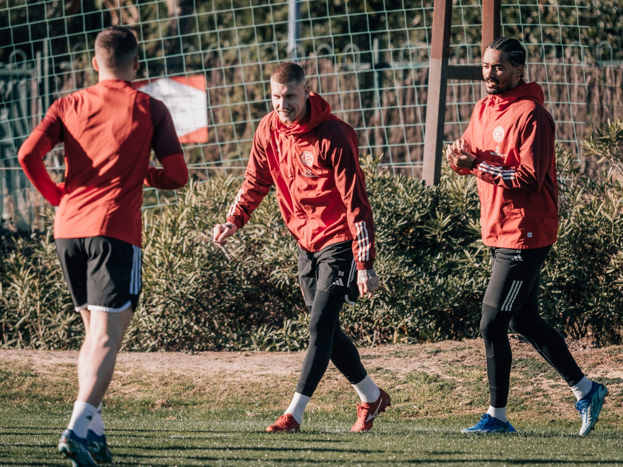 Christos Tzolis, Jordy de Wijs und Emmanuel Iyoha laufen über den Trainingsplatz.