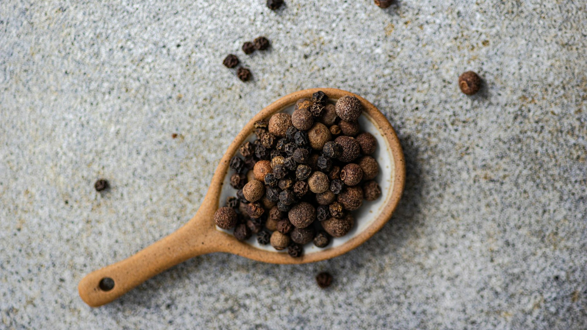 Schwarzer Pfeffer auf einem Holzlöffel