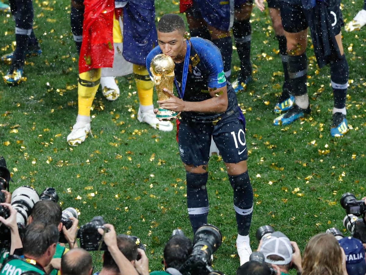 Kylian Mbappé küsst 2018 vor Fotografen den WM-Pokal.