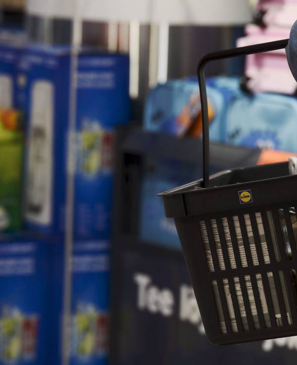 Ein Kunde trägt einen Einkaufskorb in einer Lidl-Filiale.