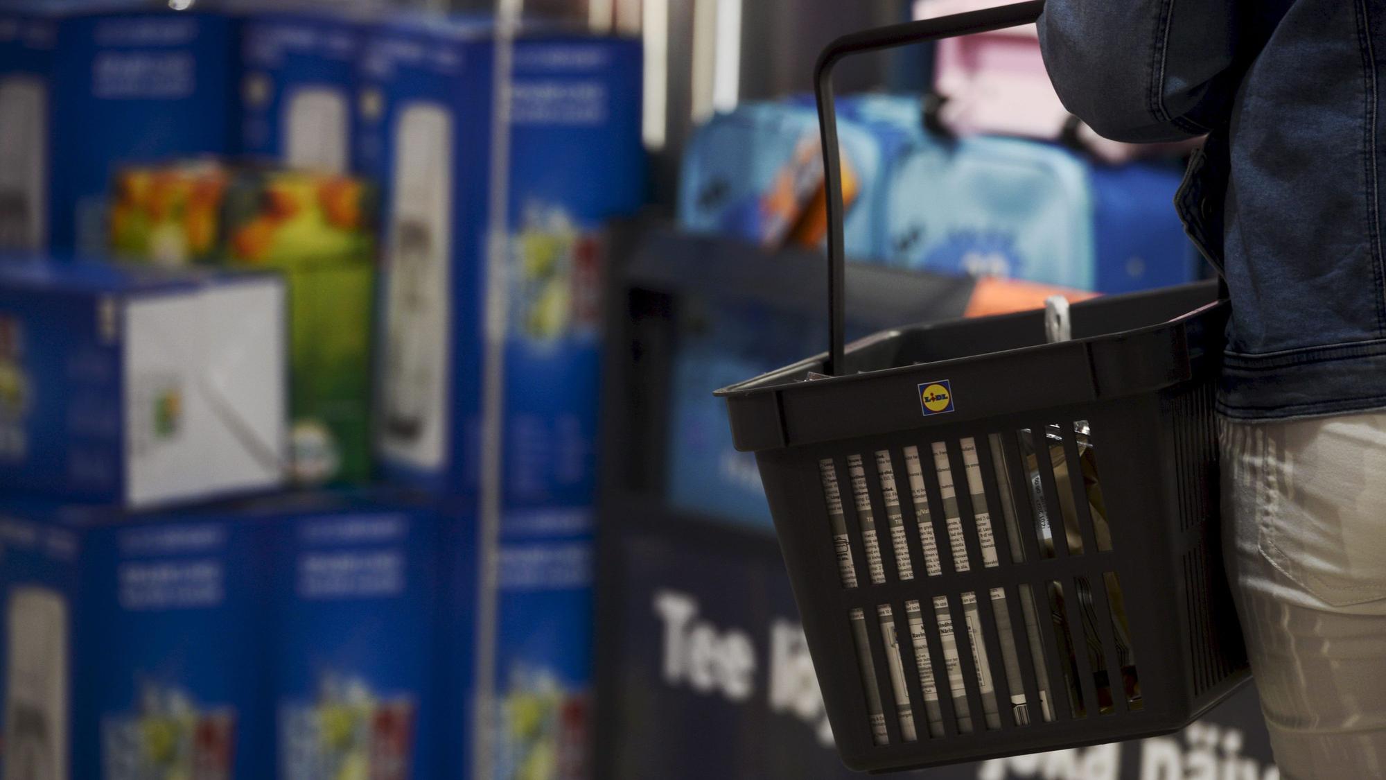 Ein Kunde trägt einen Einkaufskorb in einer Lidl-Filiale.