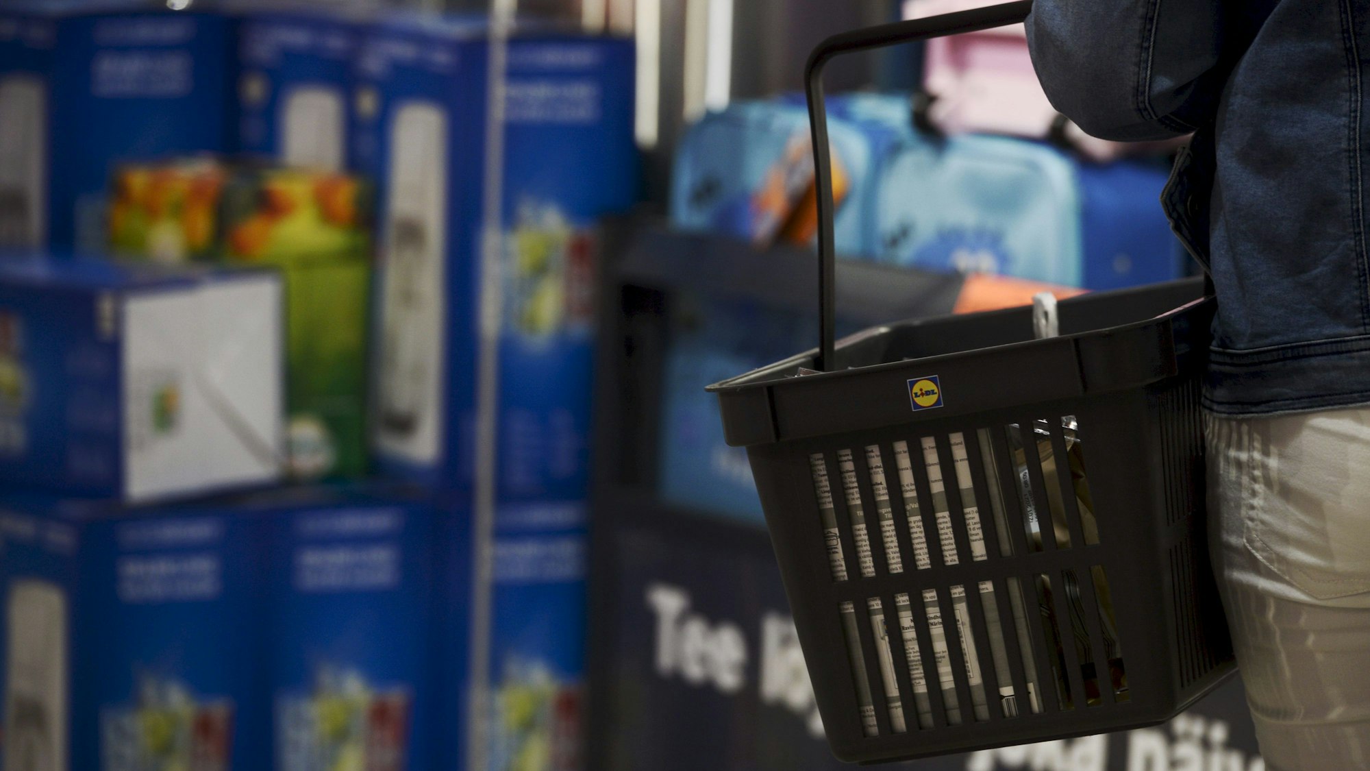 Ein Kunde trägt einen Einkaufskorb in einer Lidl-Filiale.