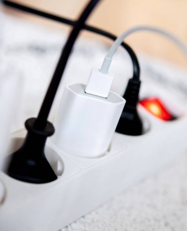 Die Netzstecker mehrerer Elektrogeräte stecken in einer Steckdosenleiste in einem Wohnzimmer, hier im November 2022 in Oldenburg.