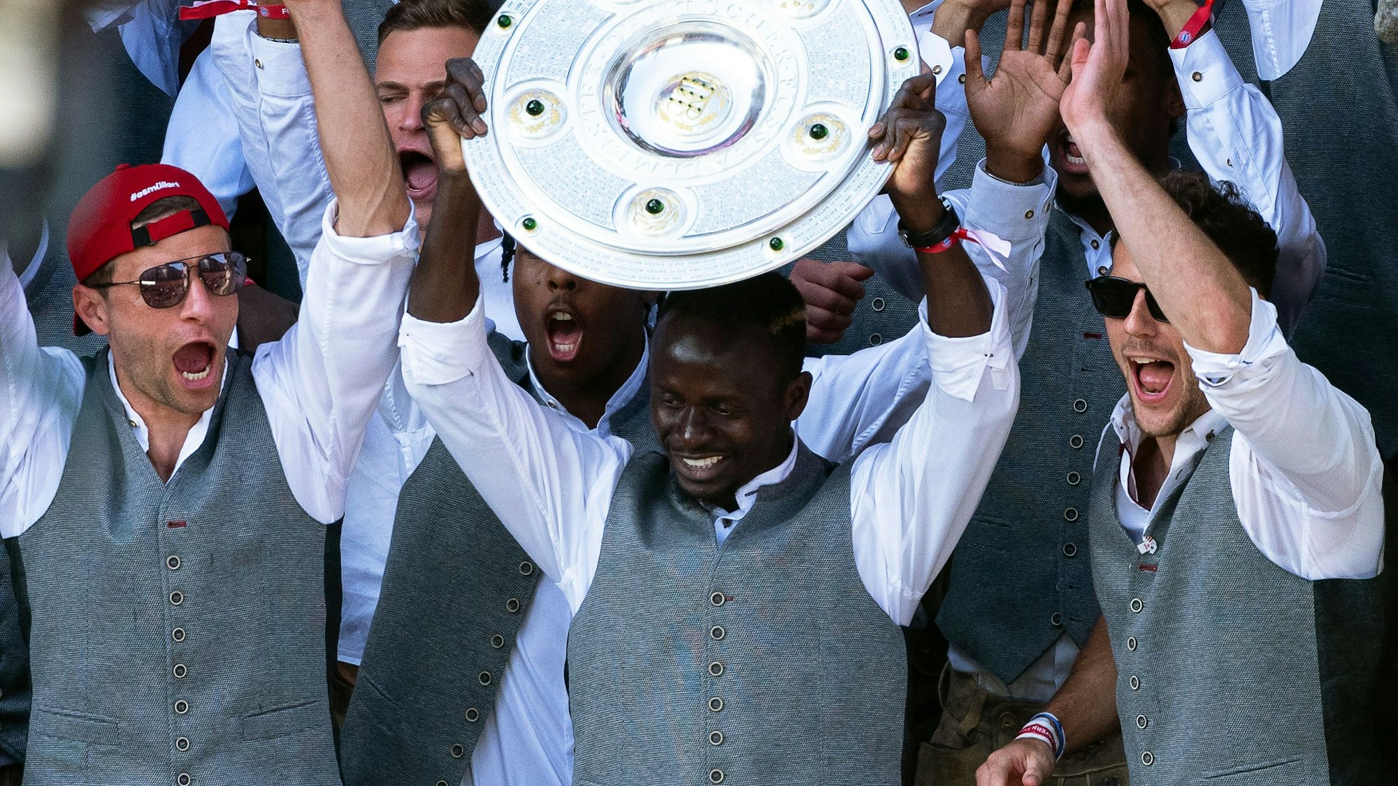 Sadio Mané hält die Meisterschale hoch. Neben ihm jubeln Thomas Müller und Leon Goretzka.