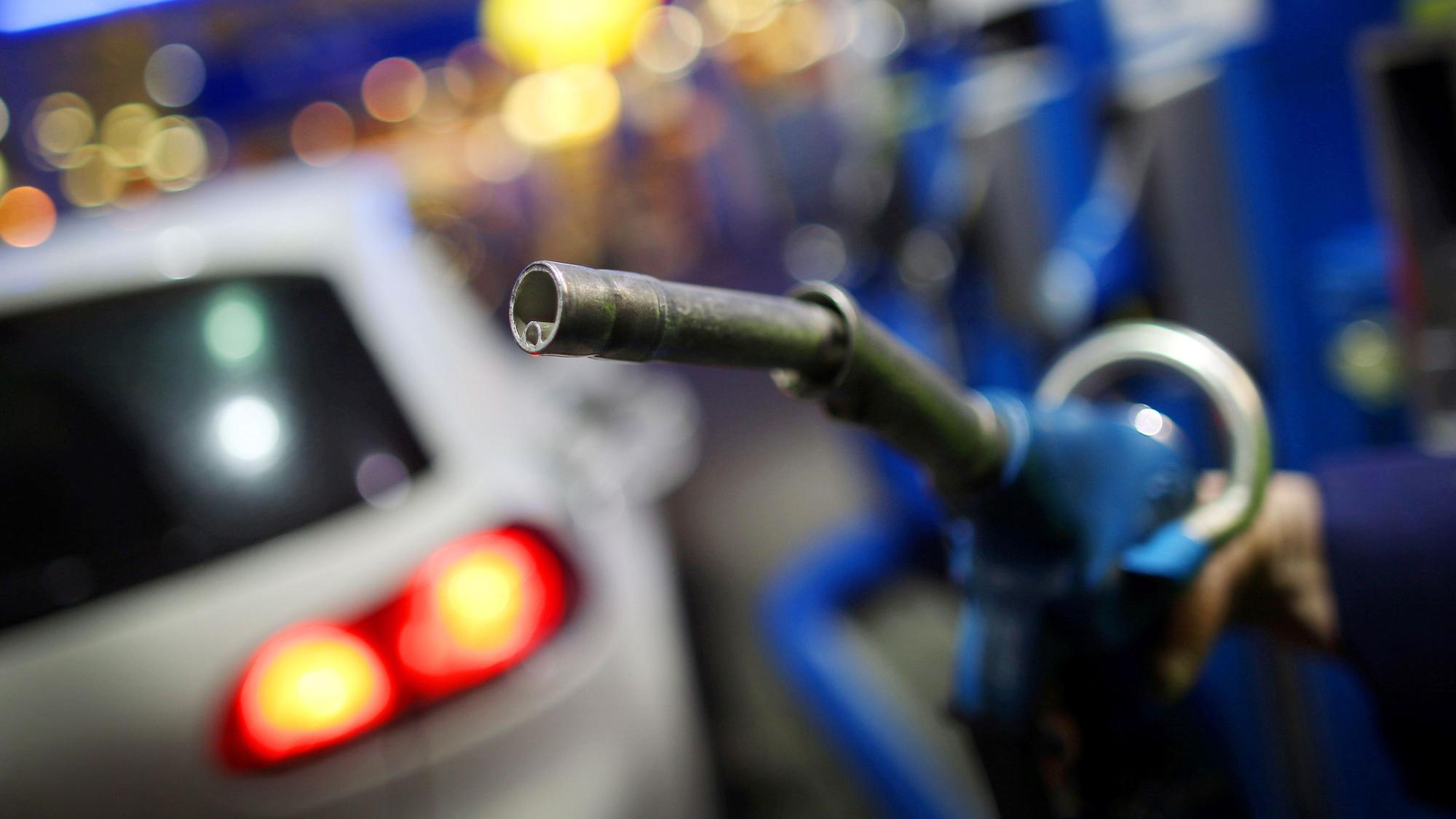 Ein Mann nimmt am 10. Februar 2014 in Rommerskirchen (Rhein-Kreis Neuss/Nordrhein-Westfalen) an einer Aral-Tankstelle einen Tankrüssel in die Hand.