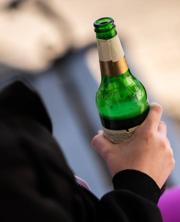 Eine Person hält eine Flasche Bier in der Hand, hier im März 2022 in Rottweil.
