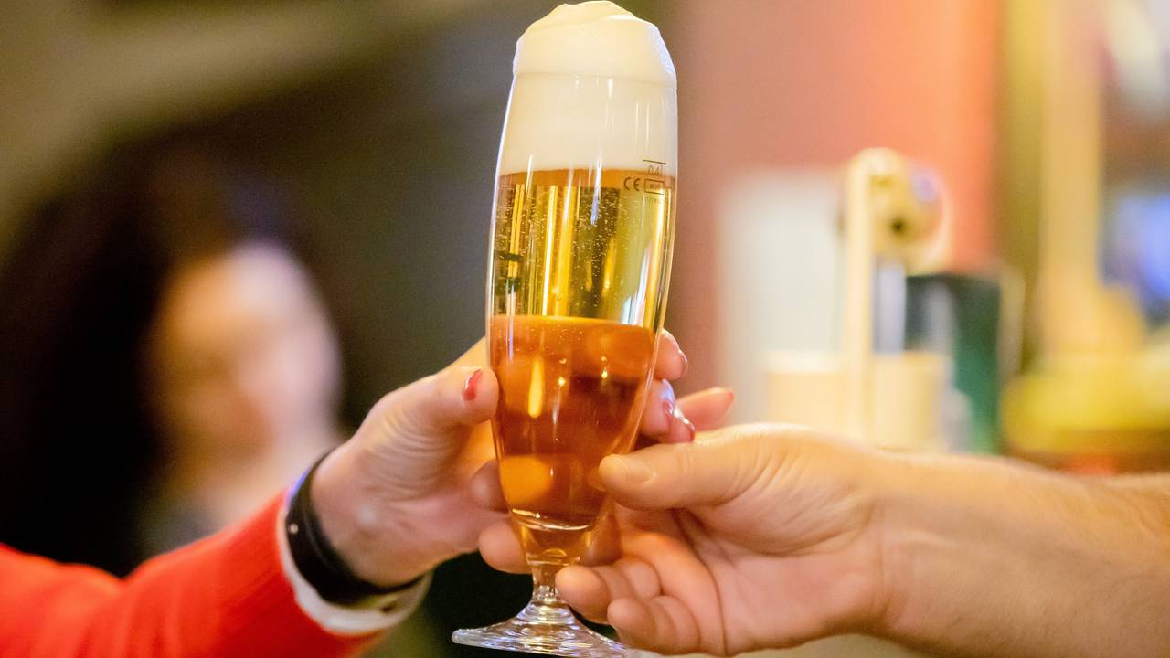 Ein Kneipenwirt reicht in einer Berliner Gaststätte einem Gast ein Bier, hier im Februar 2023.