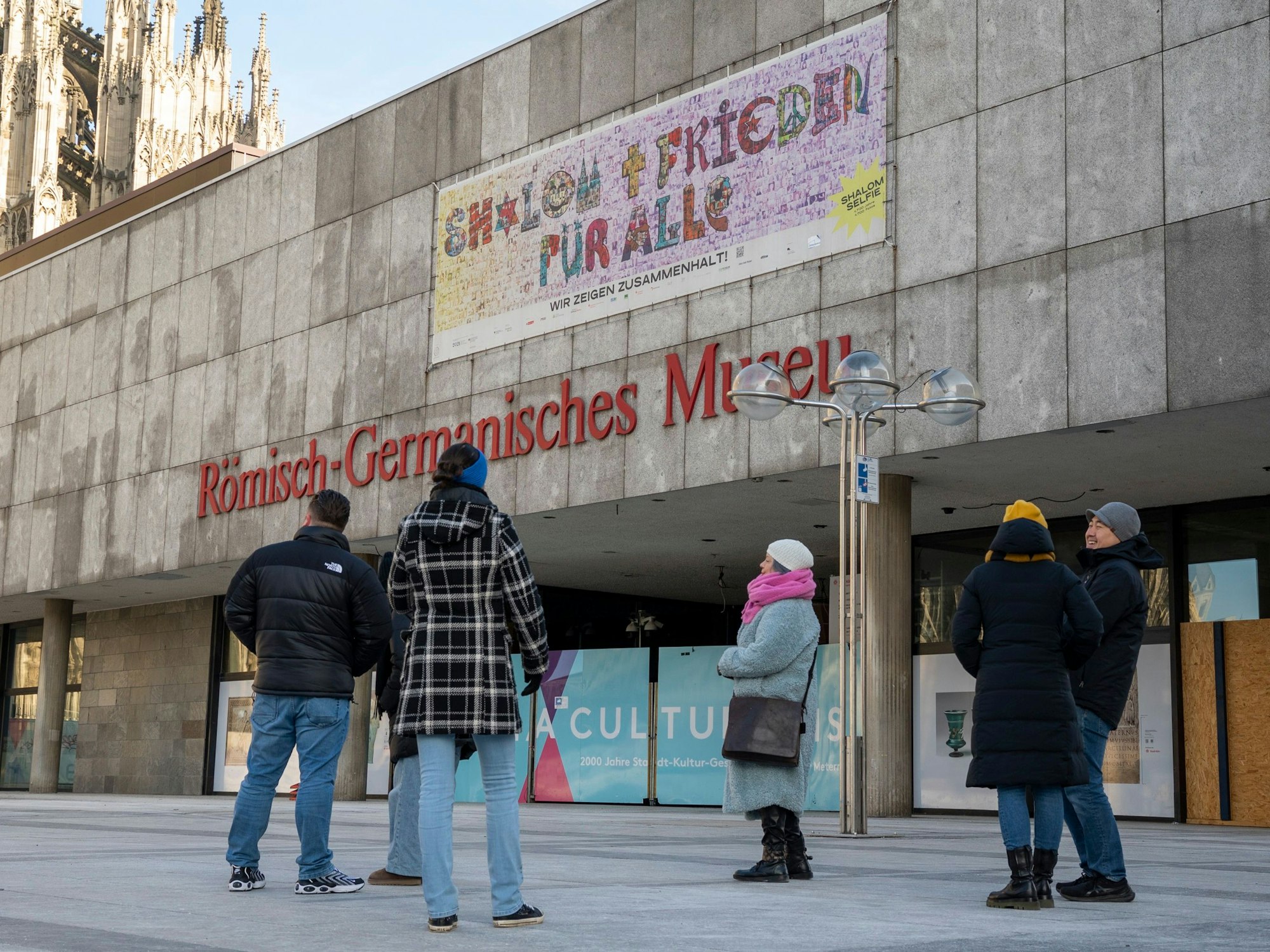 Menschen stehen vor dem Römisch-Germanischen-Museum in Köln.