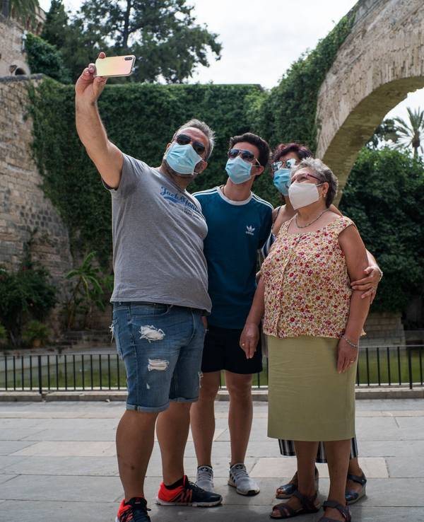 Die Maske gehörte im Sommer 2020 zum Stadtbild in Palma de Mallorca, hier posieren mehrere Touris neben der Kathedrale Santa Maria.