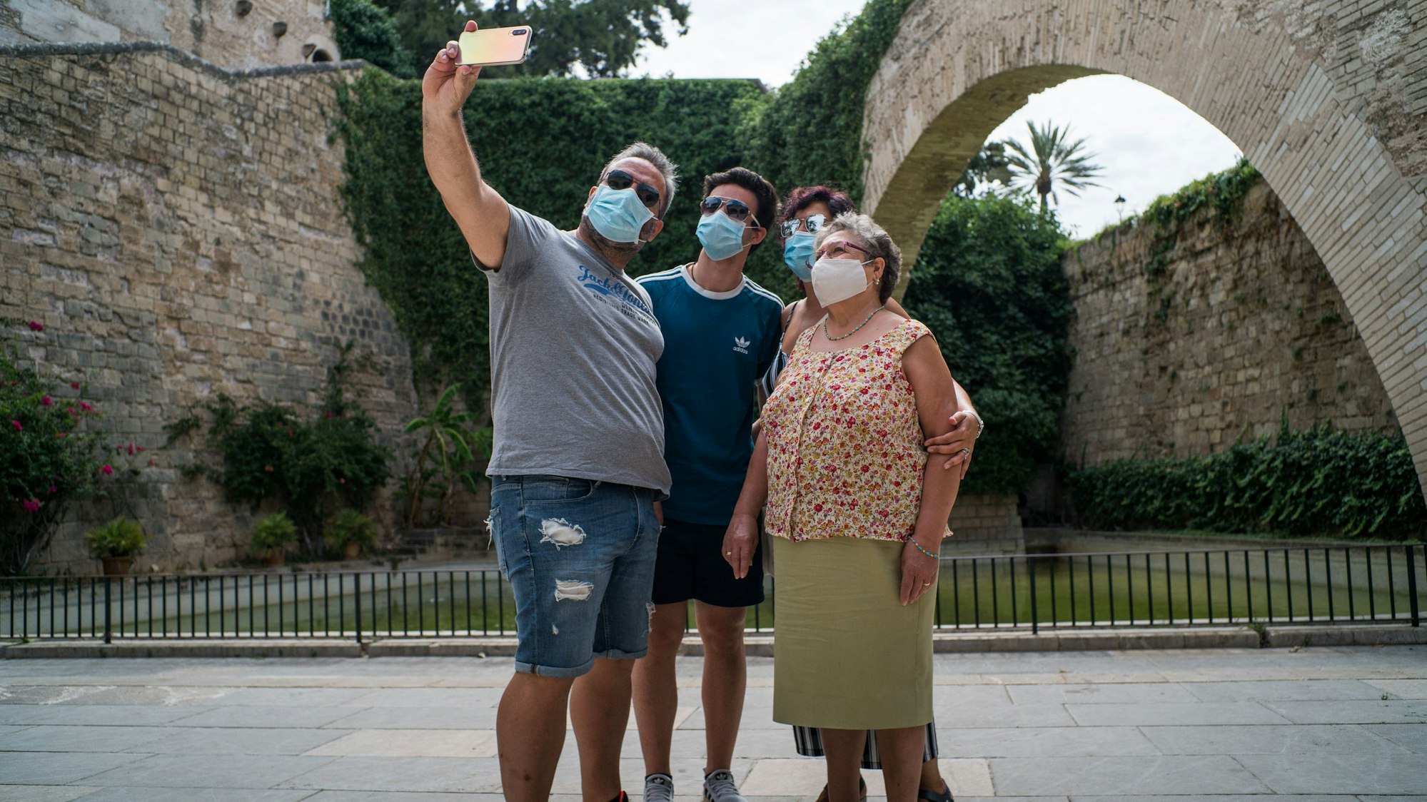 Die Maske gehörte im Sommer 2020 zum Stadtbild in Palma de Mallorca, hier posieren mehrere Touris neben der Kathedrale Santa Maria.