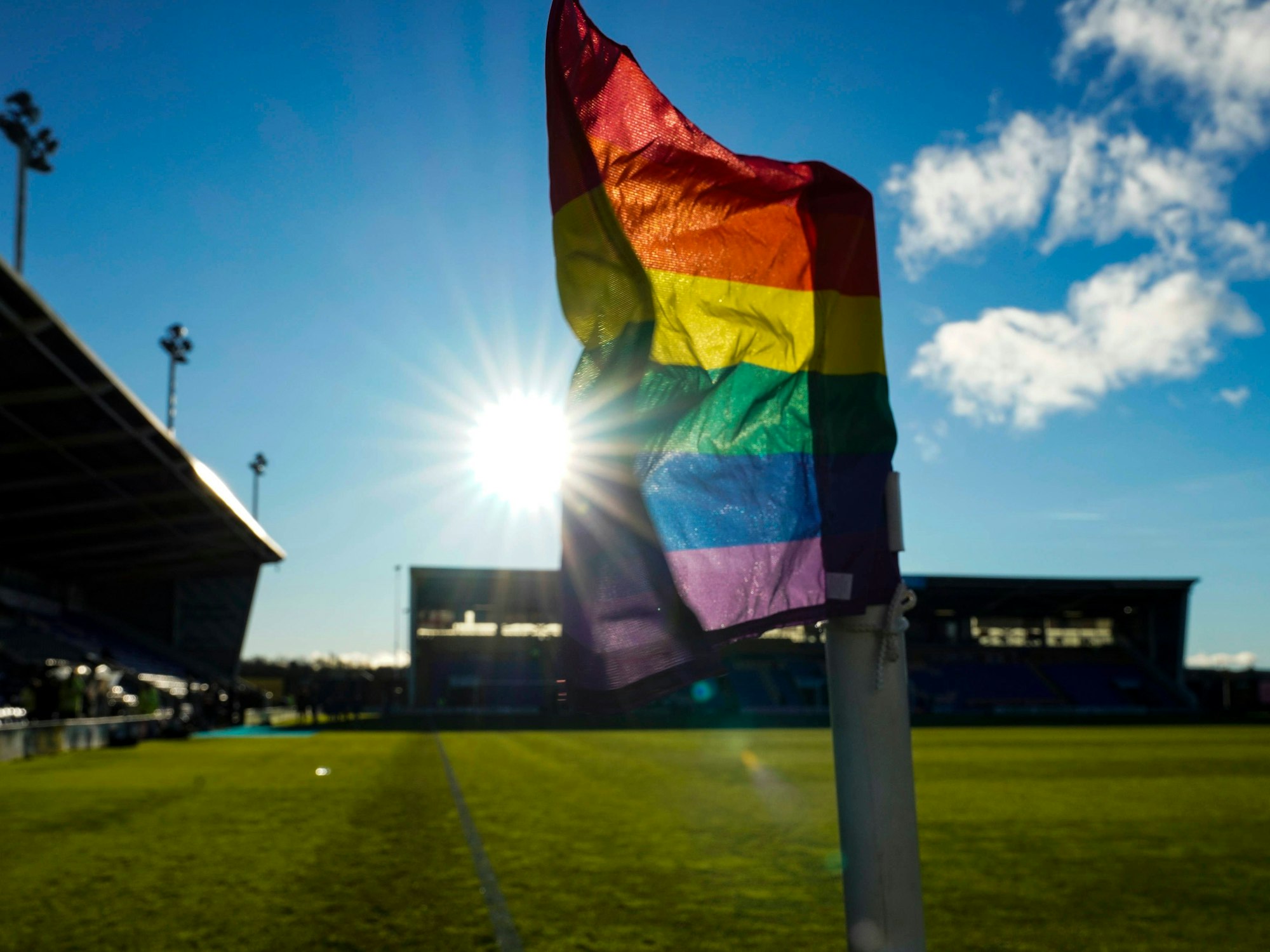 Eine Regenbogen-Eckfahne in einem Stadion.