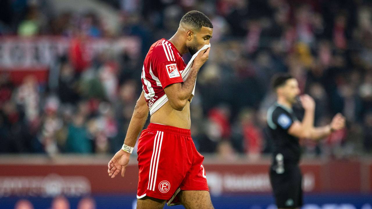Fortuna Düsseldorfs Abwehrspieler Jamil Siebert läuft beim Spiel gegen Holstein Kiel über den Platz und zieht sich sein Trikot ins Gesicht.