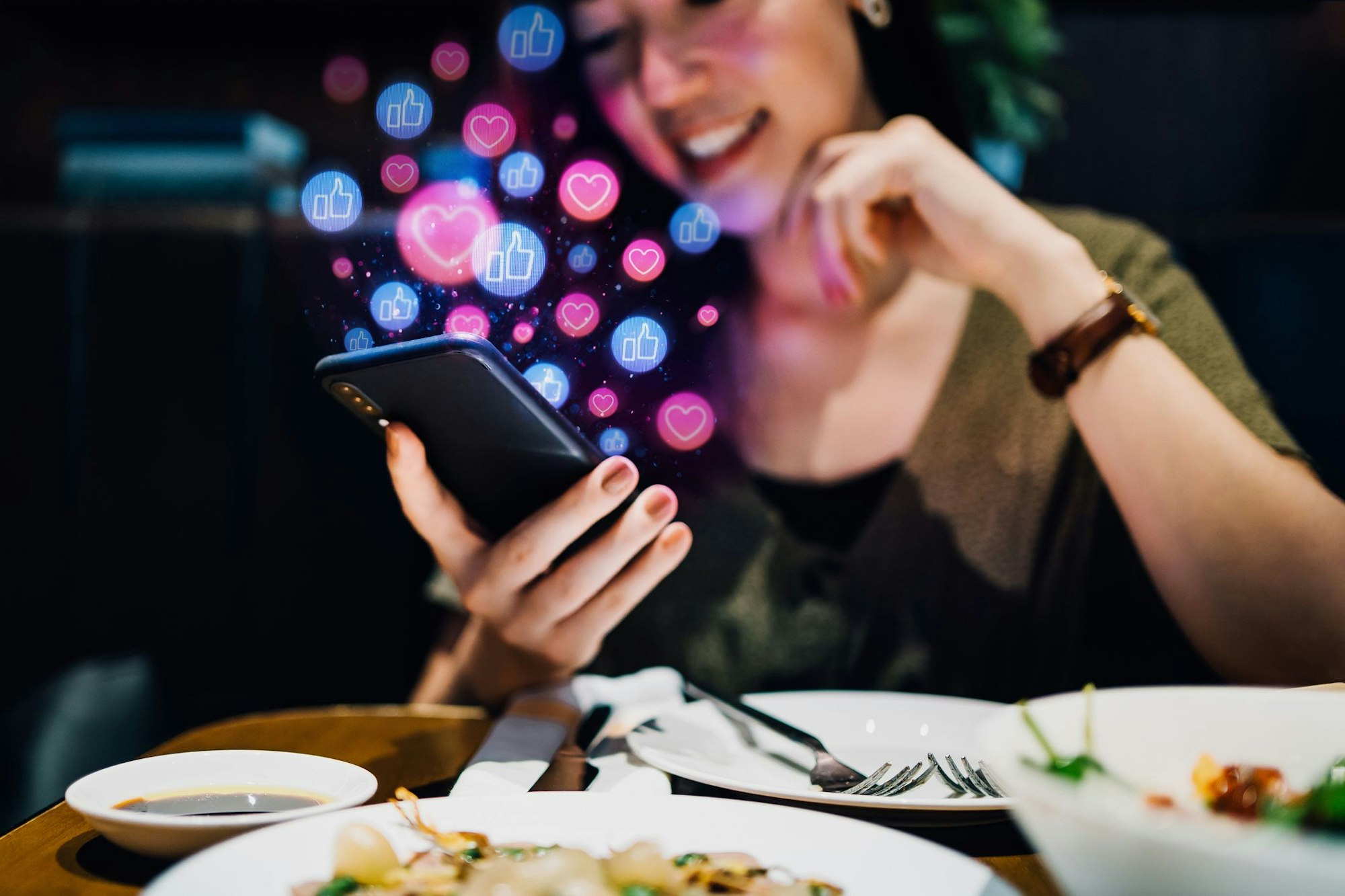Junge Frau schaut glücklich auf ihr Smartphone