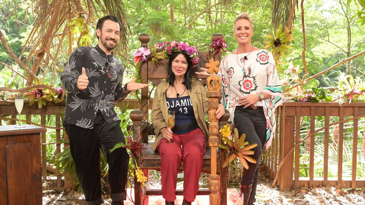 Djamila Rowe sitzt mit ihrer Krone nach dem Sieg beim RTL-Dschungelcamp 2023 auf ihrem Thron neben der Moderatorin Sonja Zietlow (rechts) und Moderator Jan Köppen (links), hier im Januar 2023 in Australien.