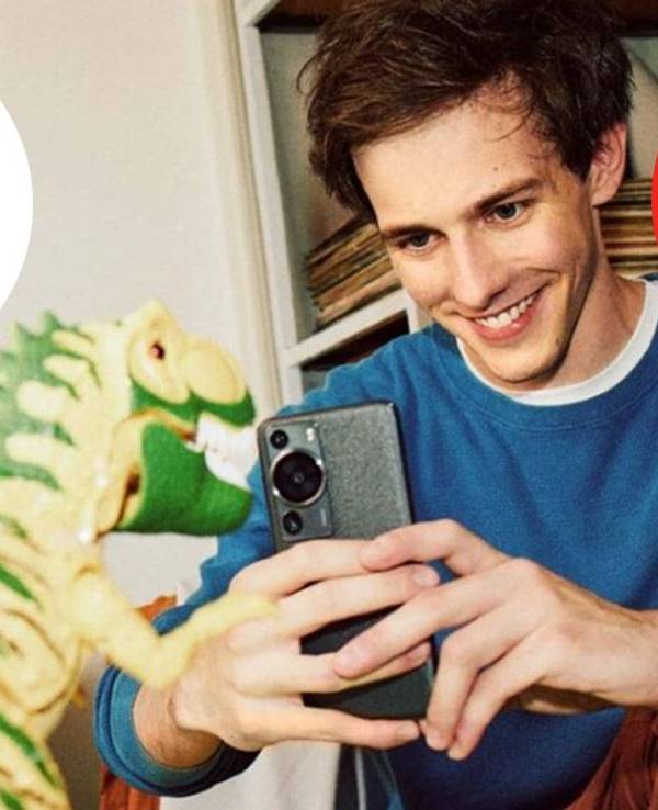 Junger Mann schießt mit dem Smartphone ein Bild von einem Spielzeug-Dinosaurier. Ebay Logo auf Bild.